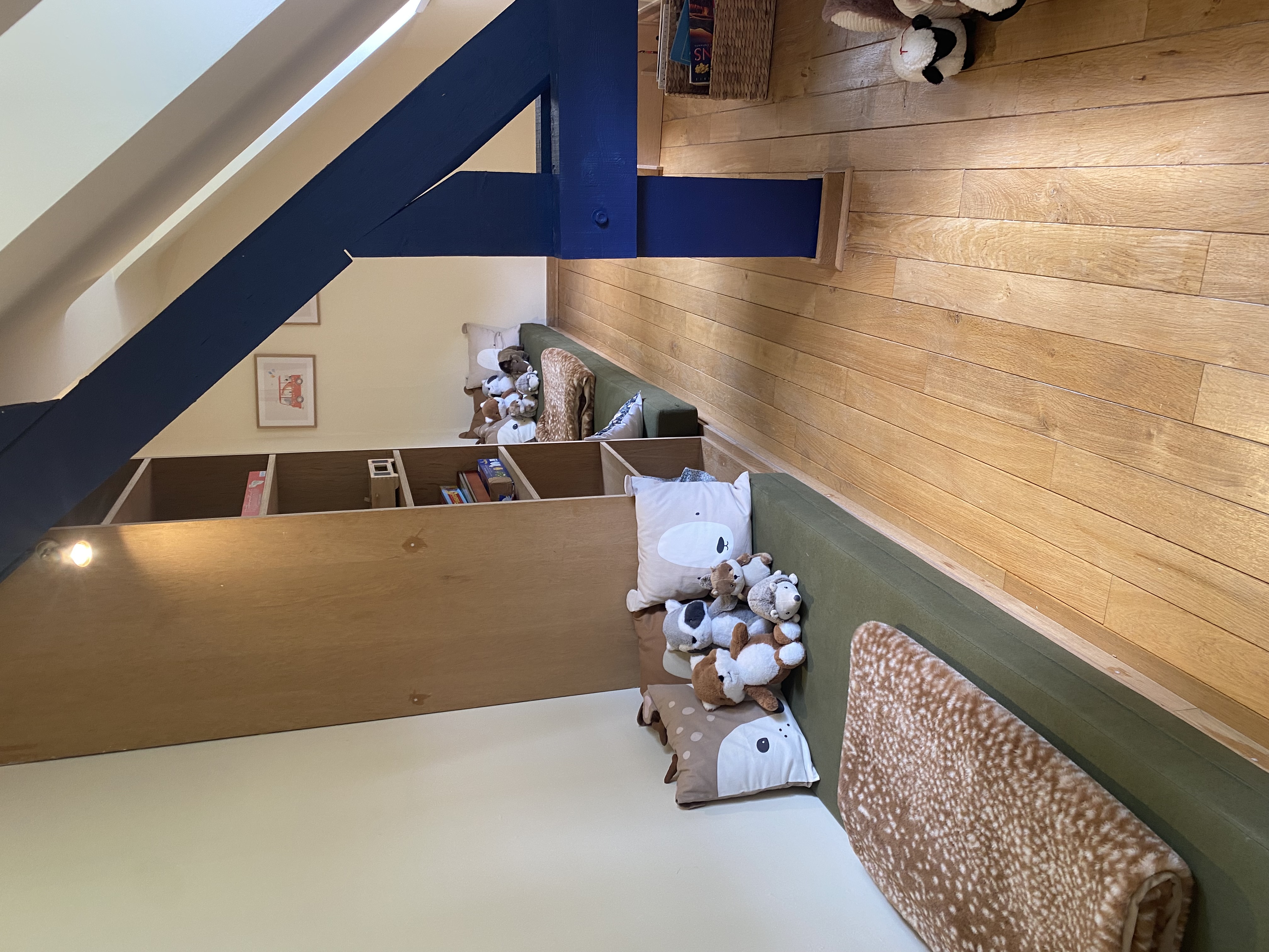 Coin lecture et jeux pour enfants avec coussins et peluches sous les combles