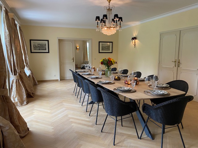 Salle à manger élégante avec longue table dressée et rideaux dorés
