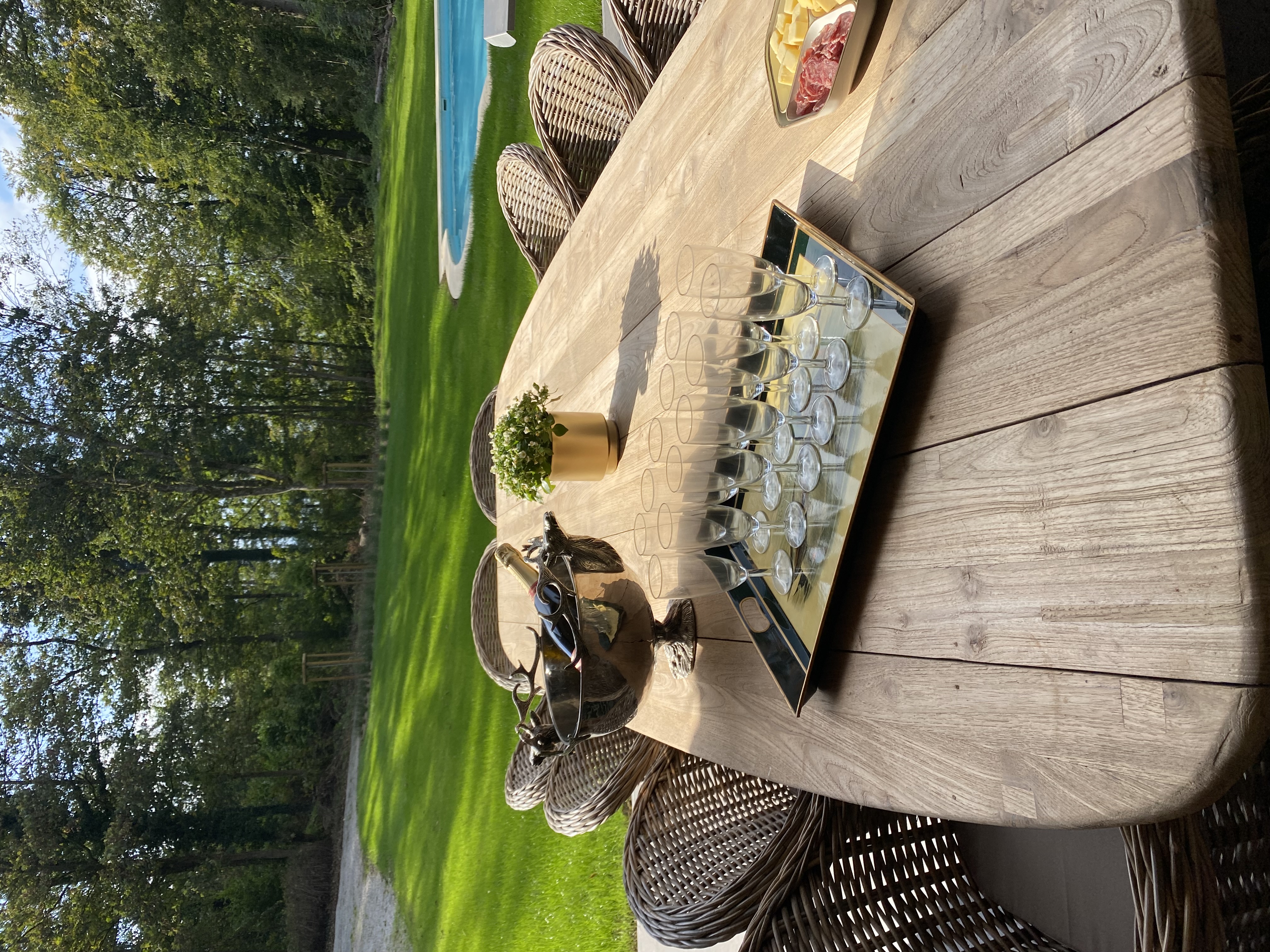 Table de jardin avec champagne et flûtes au bord de la piscine