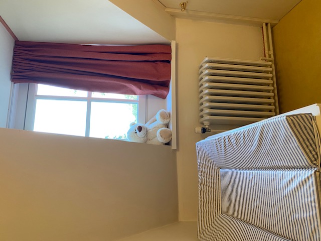 Coin bébé avec matelas à langer et peluche sur le rebord de la fenêtre